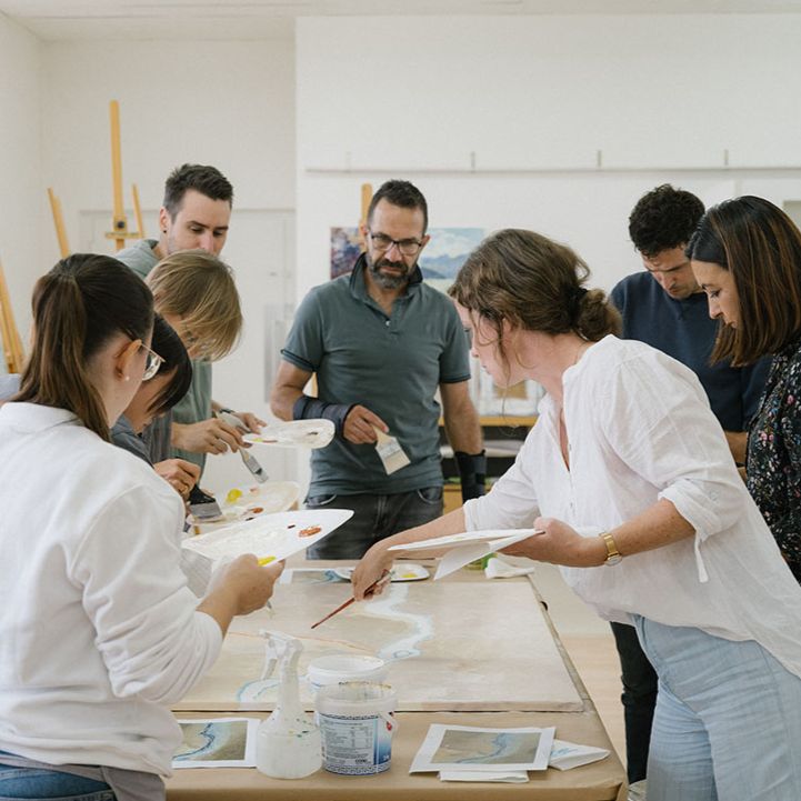 Teamevents Team malt an einem Gemeinschaftsbild im Atelier